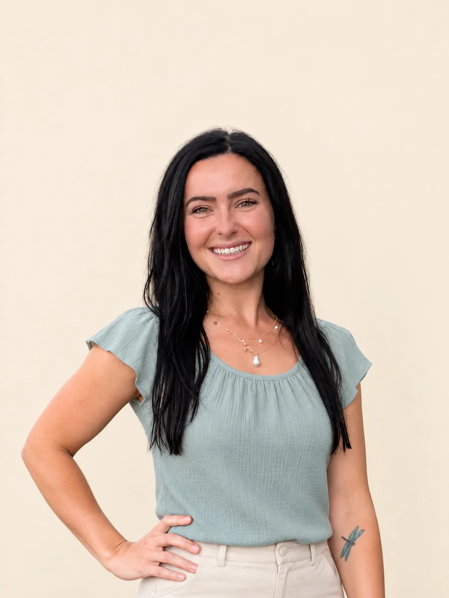 Alissa Ruder smiling, in a sage top against a soft cream wall